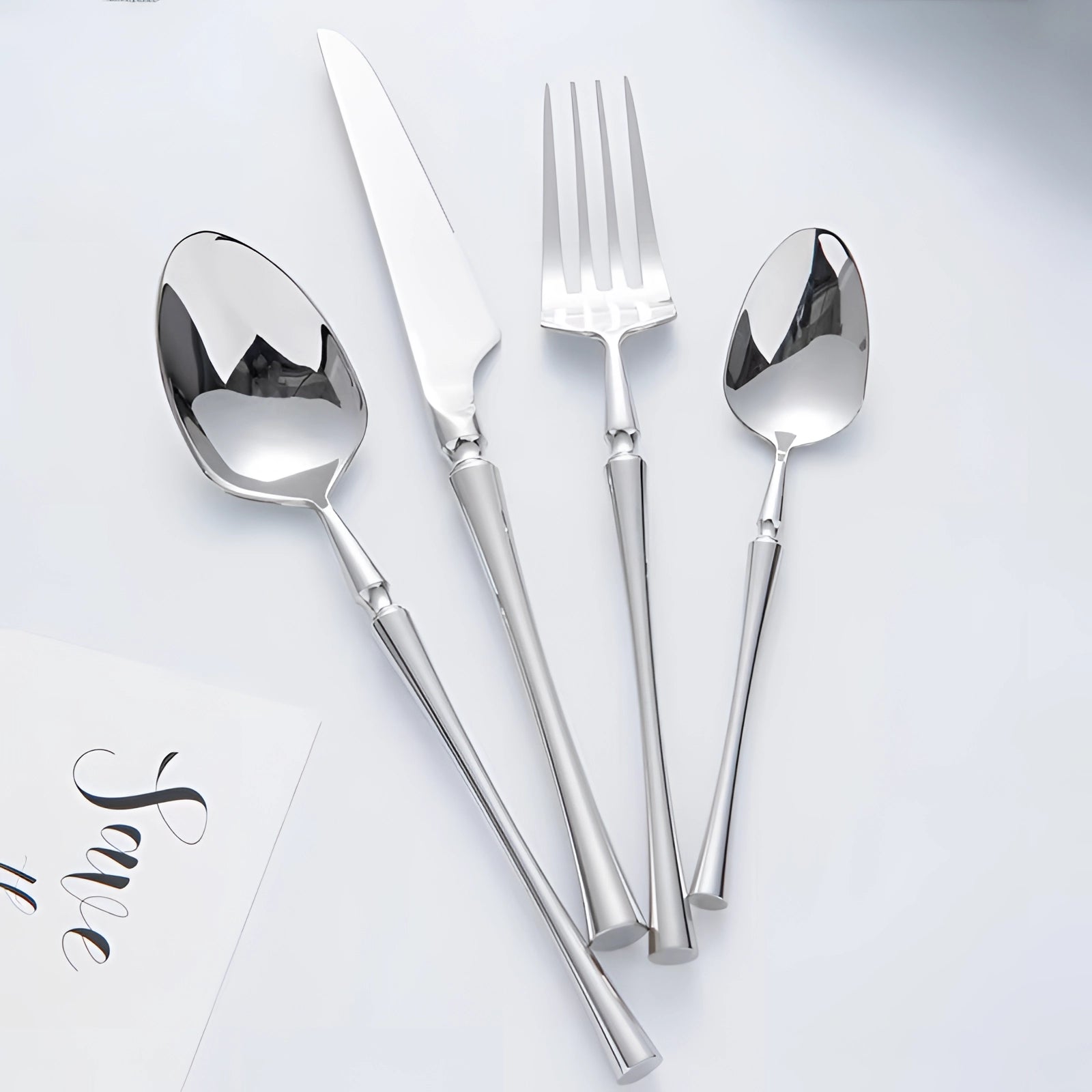 Luxury silver cutlery set with elegant stainless steel silverware displayed on a white background, showcasing the shiny metallic finish and sophisticated design of the utensils.