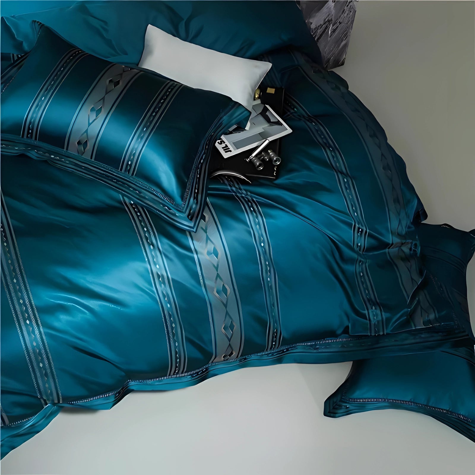 Luxury teal silk bedding set featuring a satin duvet cover and designer pillowcases with an aqua and azure color scheme. The high-quality textile material showcases a subtle pattern, adding an elegant touch to the linens.