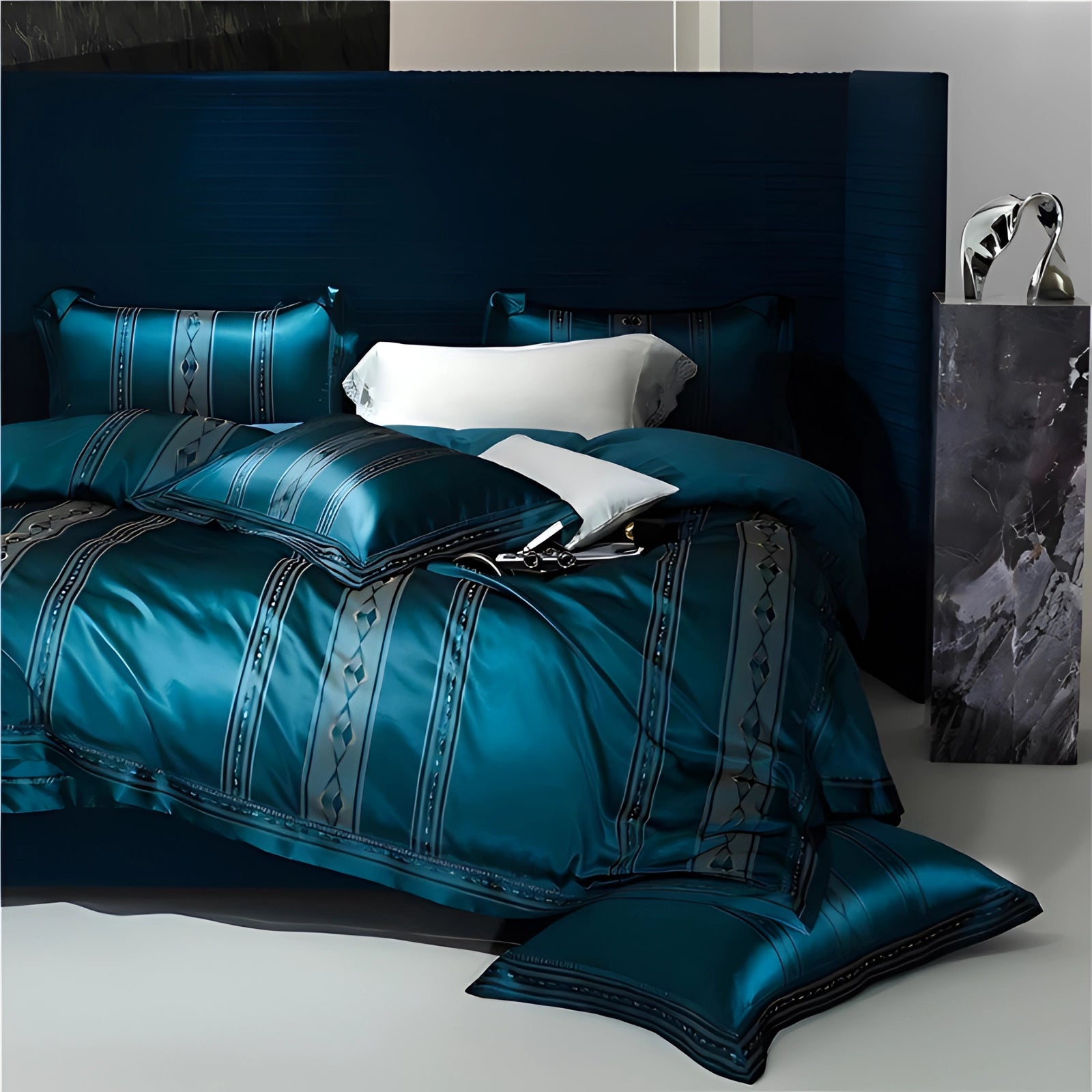 Luxurious teal silk bedding set featuring a satin duvet and designer pillowcase, displayed on a studio couch, showcasing its rich azure color and plush texture.