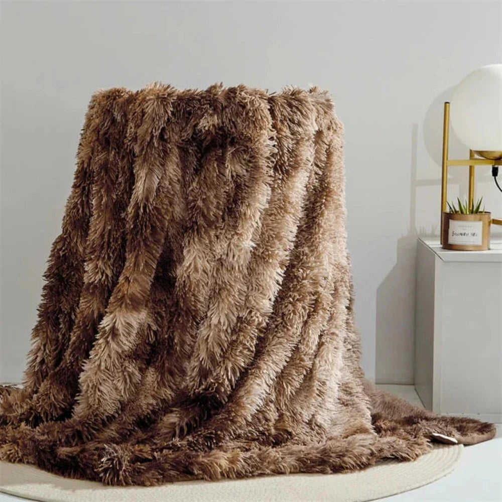 Luxurious white faux fur blanket with a textured plush design, draped elegantly over a wooden surface, in an espresso color variant measuring 200x300cm, surrounded by nature-inspired elements.