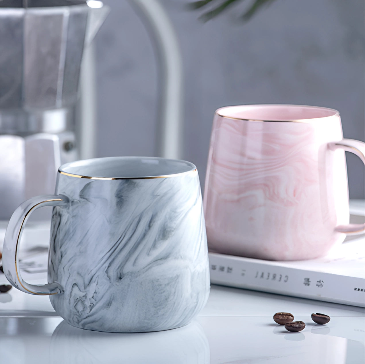 A marble coffee mug with a metallic handle in shades of pink, grey, and white, designed for serving hot beverages.