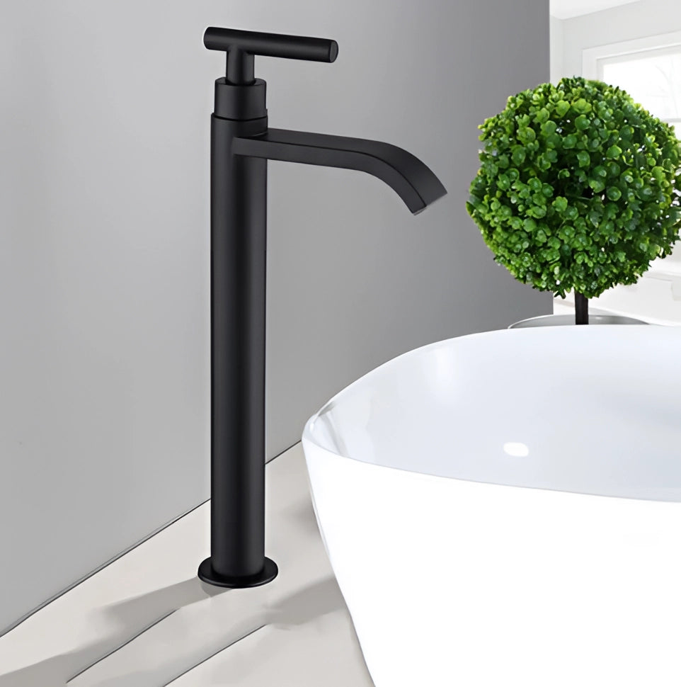 Matte black modern bathroom faucet with a sleek, minimalist design and rounding features, installed on a sink, accompanied by a small potted houseplant.