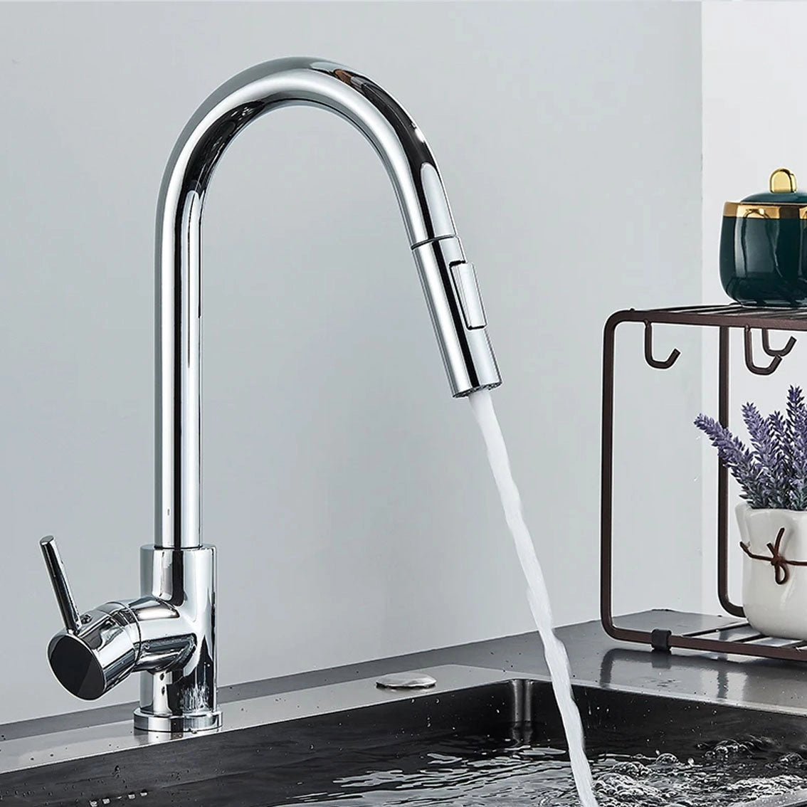 Matte black pull-down kitchen faucet with a 360° swivel spout installed over a white kitchen sink, featuring a sleek design and a silver finish.