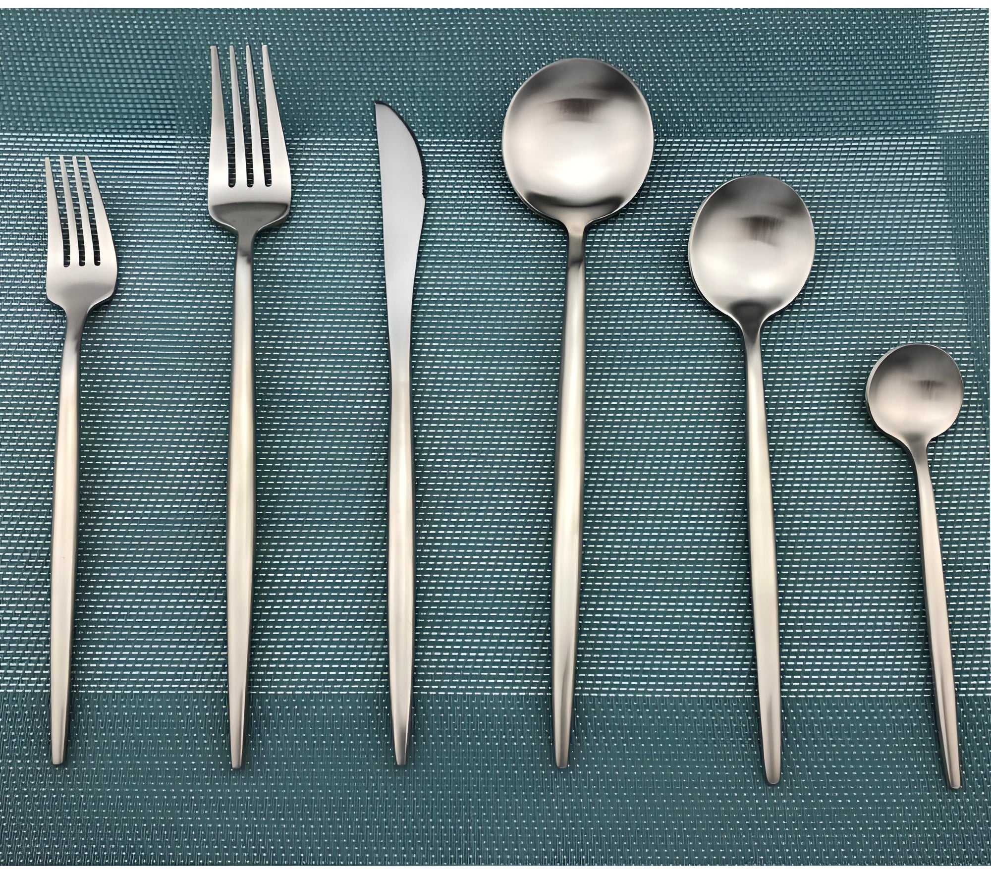 Matte silver stainless steel cutlery set consisting of 36 pieces, featuring a modern minimalist design with a rectangular handle shape, displayed against a neutral background.