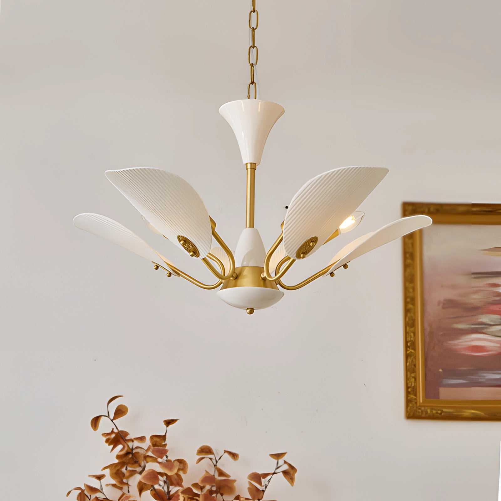 Mid-century modern brass chandelier with five white glass pendant lights, featuring a vintage design. The chandelier is suspended from the ceiling, presenting a sleek elongated structure with brass accents and a minimalist aesthetic.