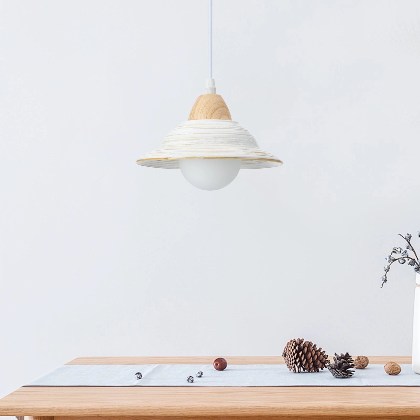 Minimalist Scandinavian wooden pendant light hanging above a Nordic dining table with a rectangular wood design and natural material shade.