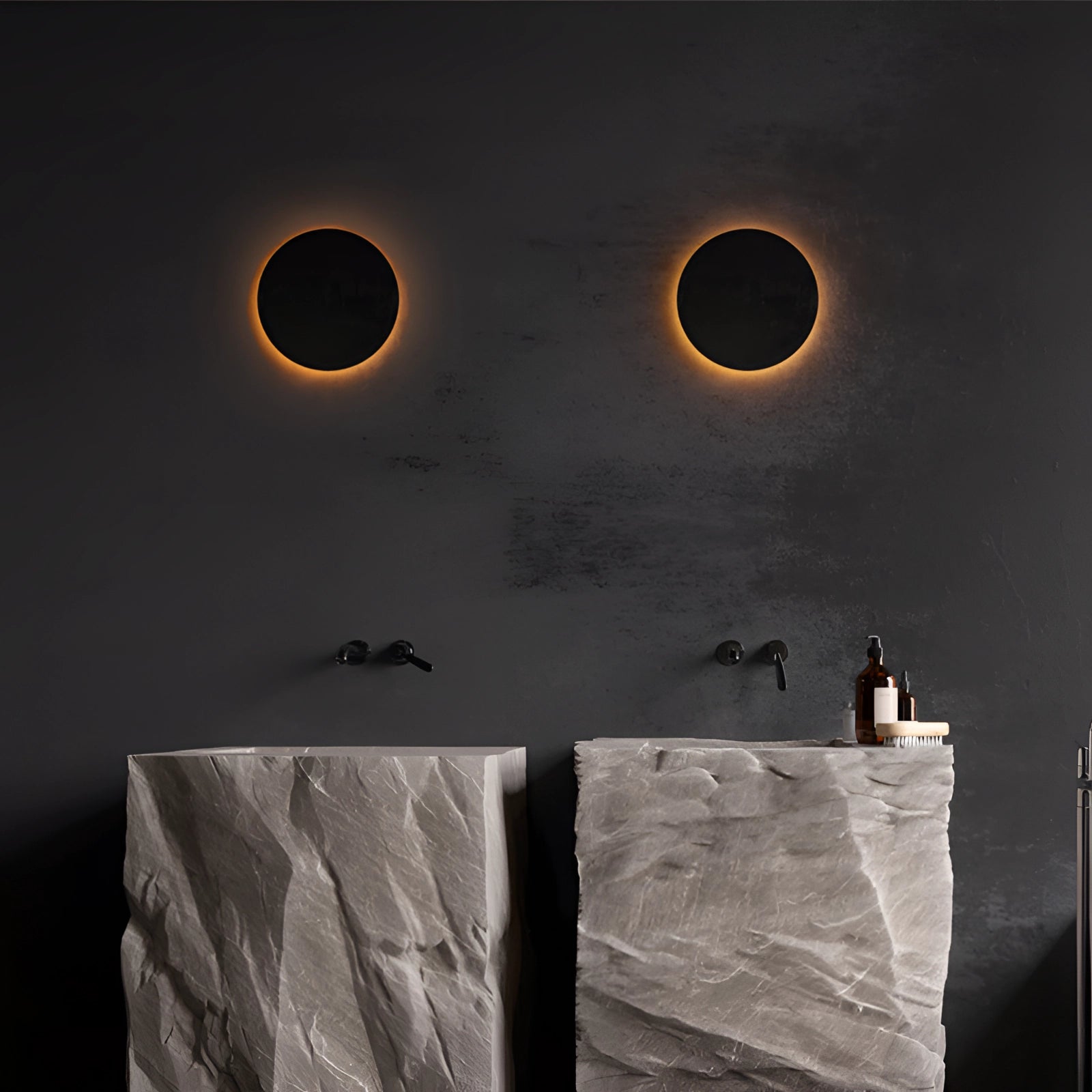 Modern black circular LED wall sconce with a minimalist design, emitting a halo glow against a dark background.