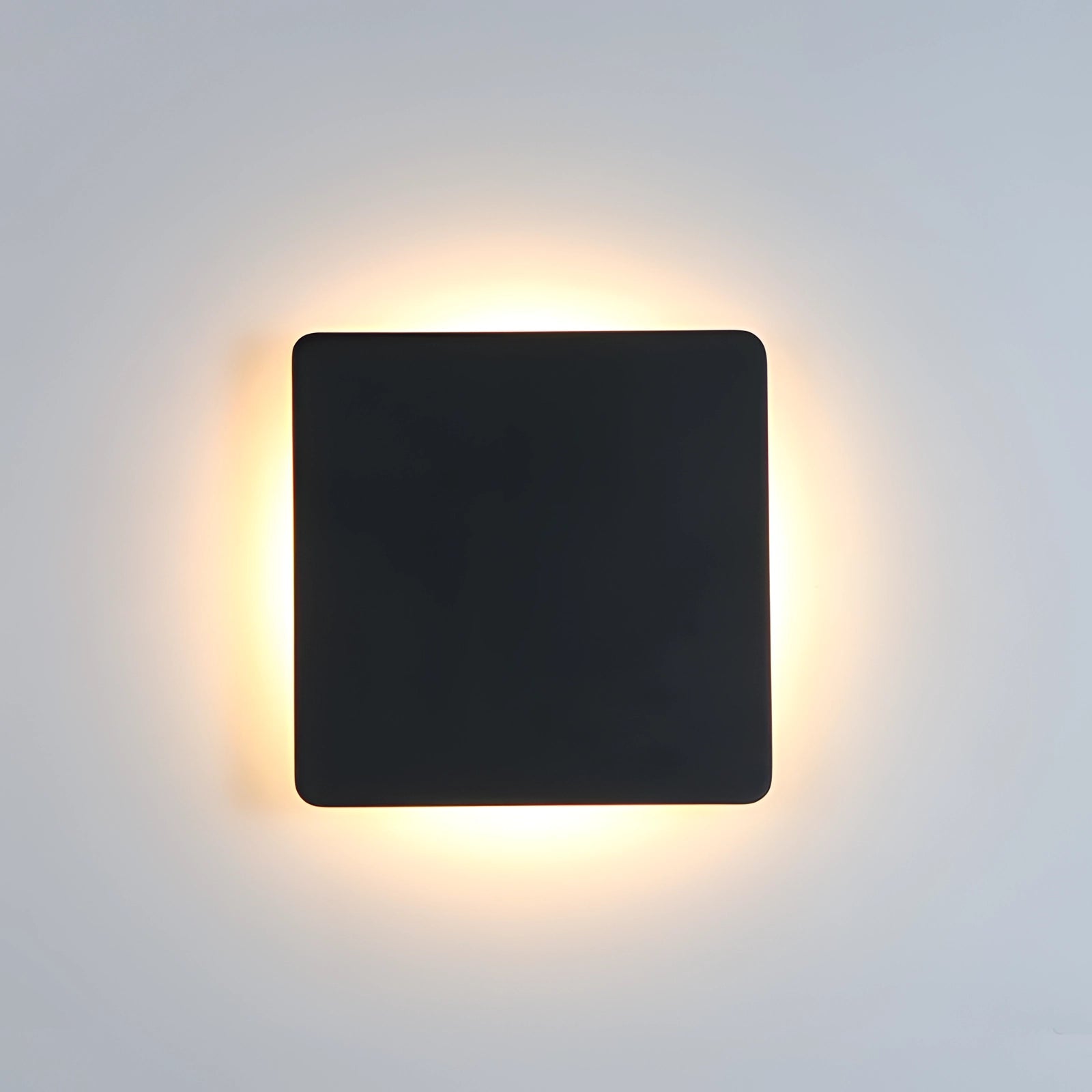 
Modern black circular LED wall sconce with a minimalist design featuring a halo glow, against a dark background.