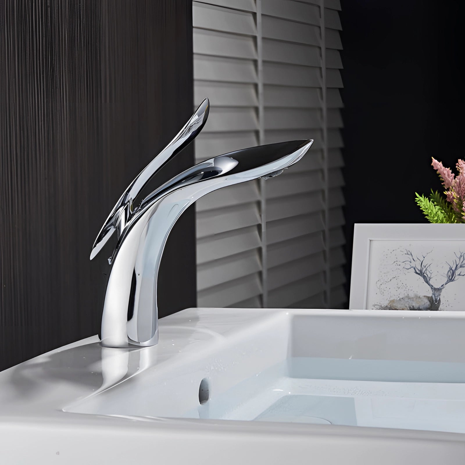 Modern black kitchen faucet with a sleek, minimalist design in a chrome finish, installed on a kitchen sink under a window. A small plant is placed nearby, adding a touch of greenery to the contemporary kitchen setting.