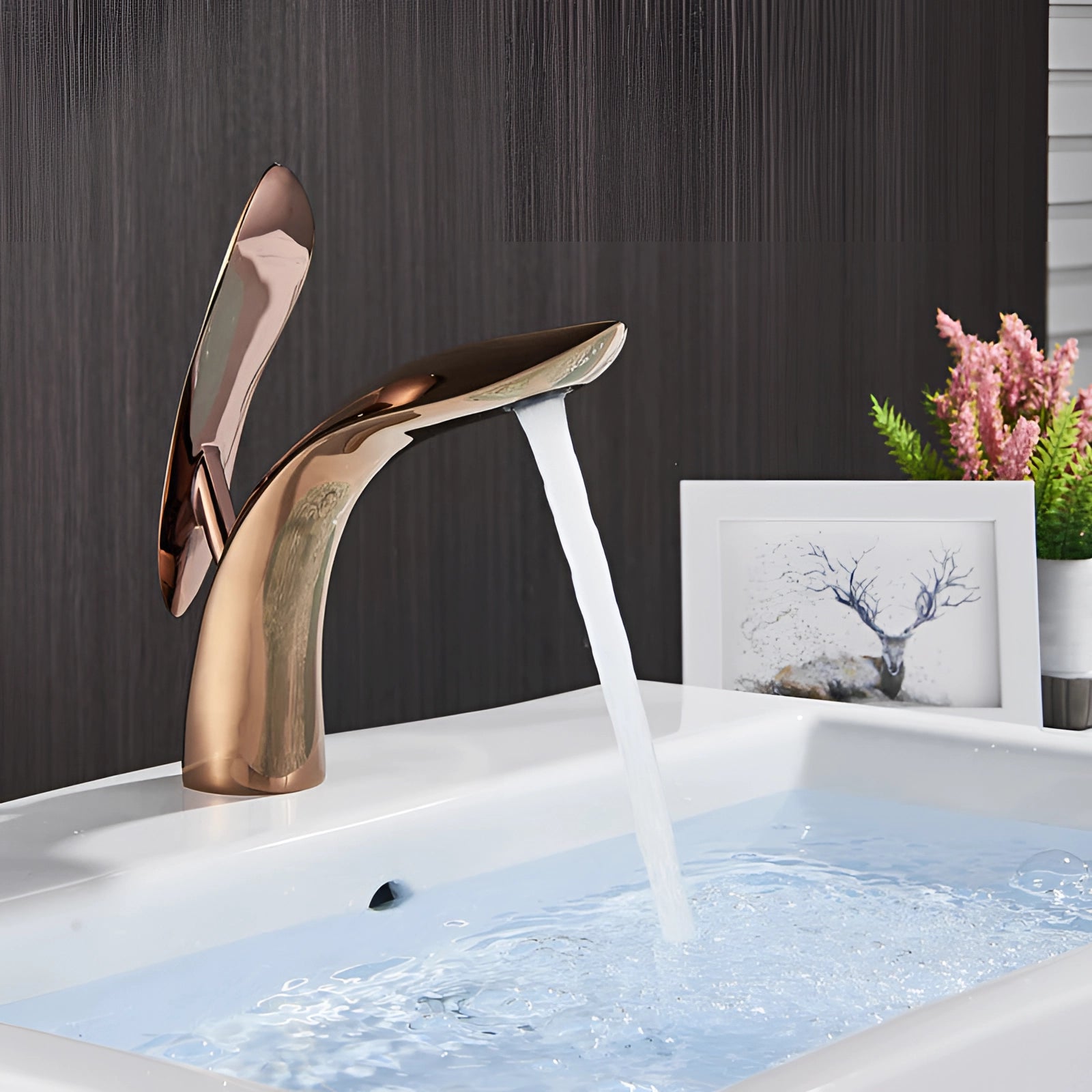 Modern black designer kitchen faucet with a minimalist luxury design, positioned above a wooden countertop with a plant nearby.