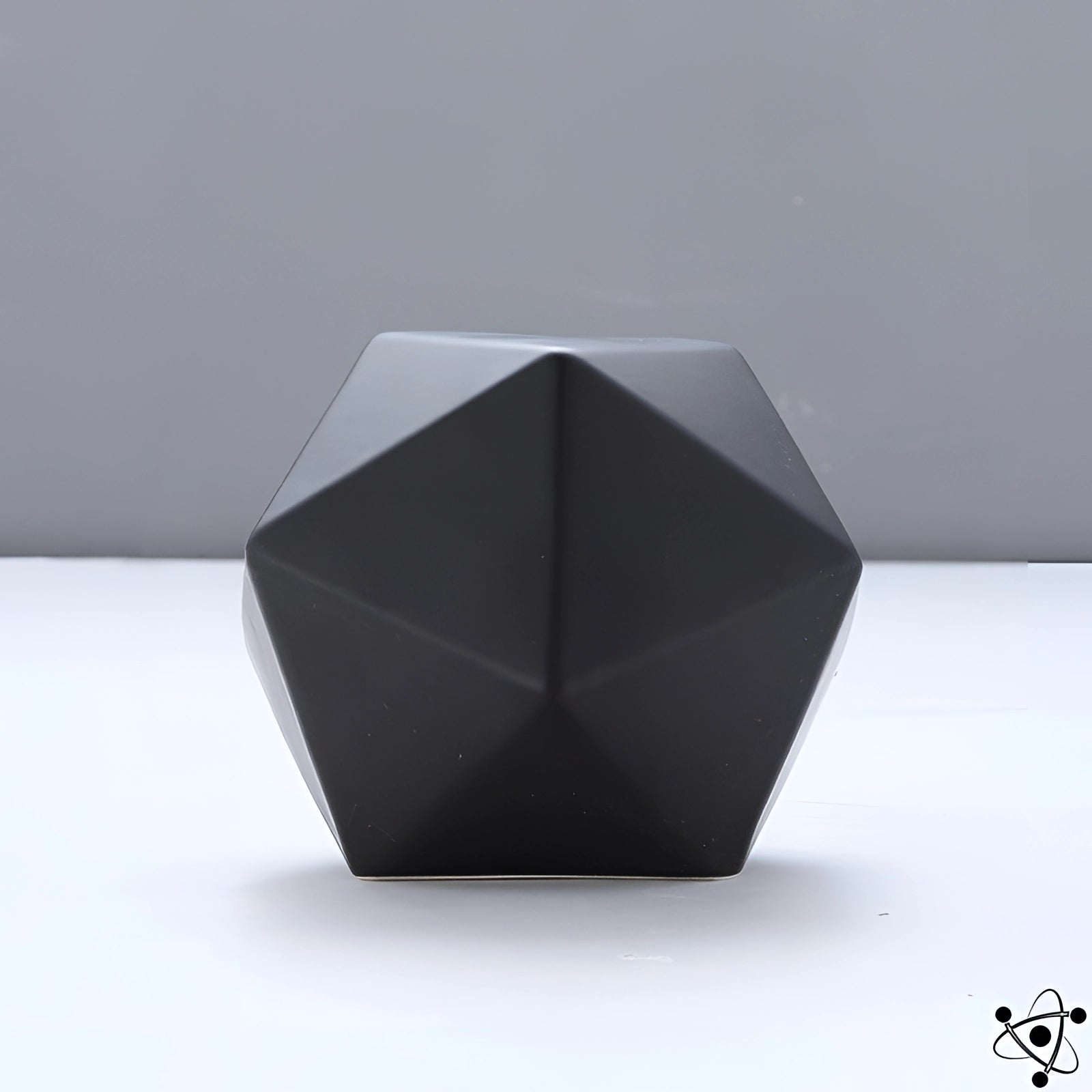 A modern black geometric faceted vase with a unique contemporary design, featuring an artistic pattern of triangles and rectangles.