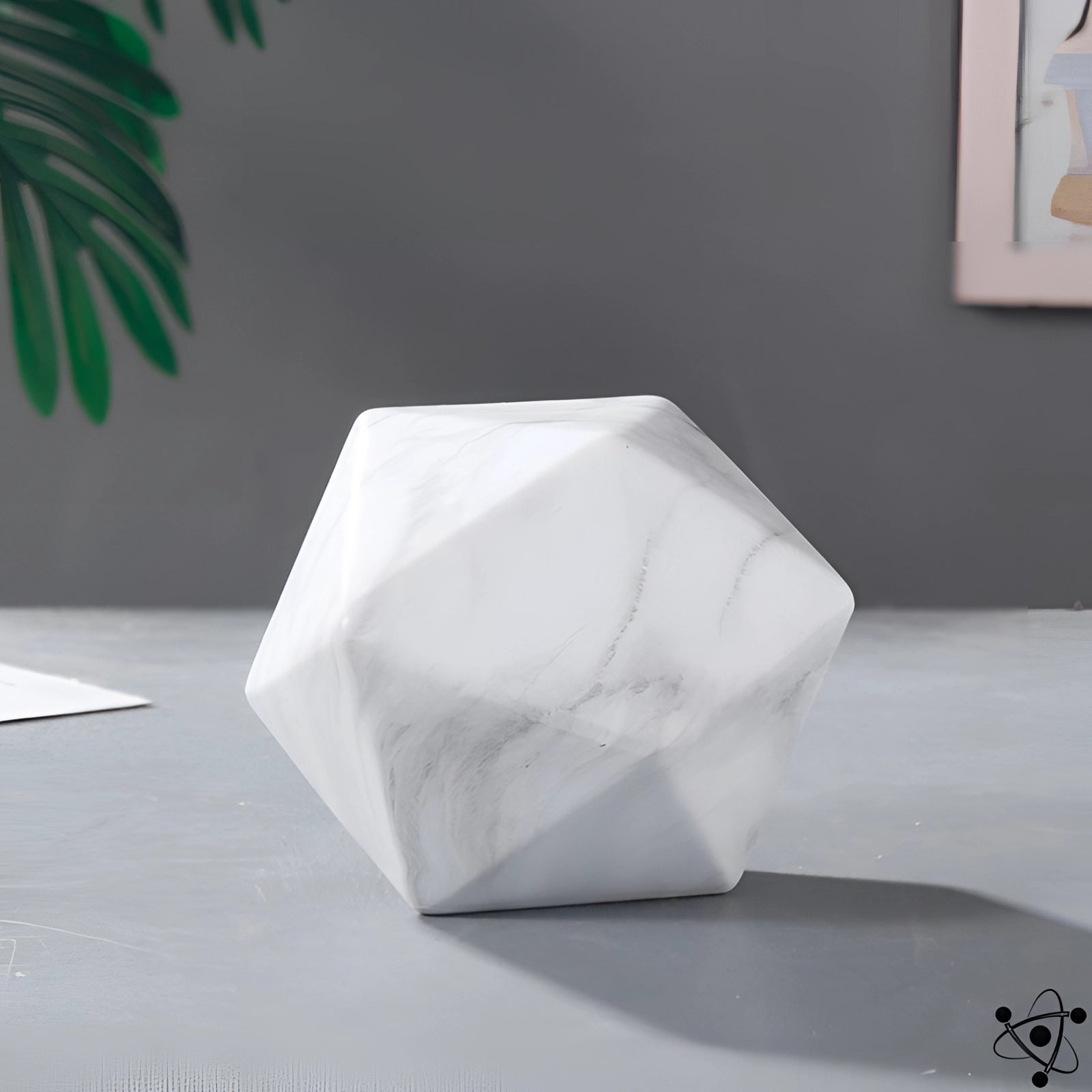 A modern geometric faceted vase with a unique contemporary design, showcased in a white marble variant. The monochrome photograph highlights the intricate angles and smooth surface of the vase, emphasizing its artistic and sculptural qualities.