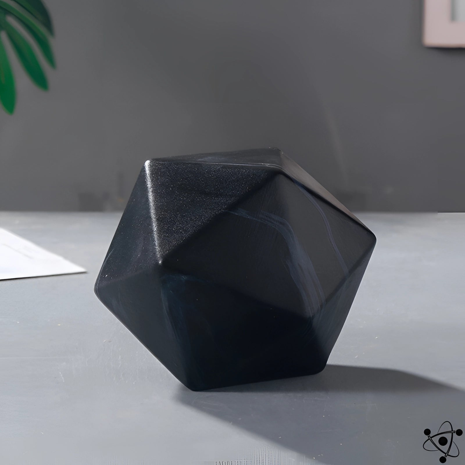 Modern black geometric faceted vase with a unique contemporary design, featuring a sleek triangular and rectangular pattern, displayed in a monochrome setting with a marble-like appearance.