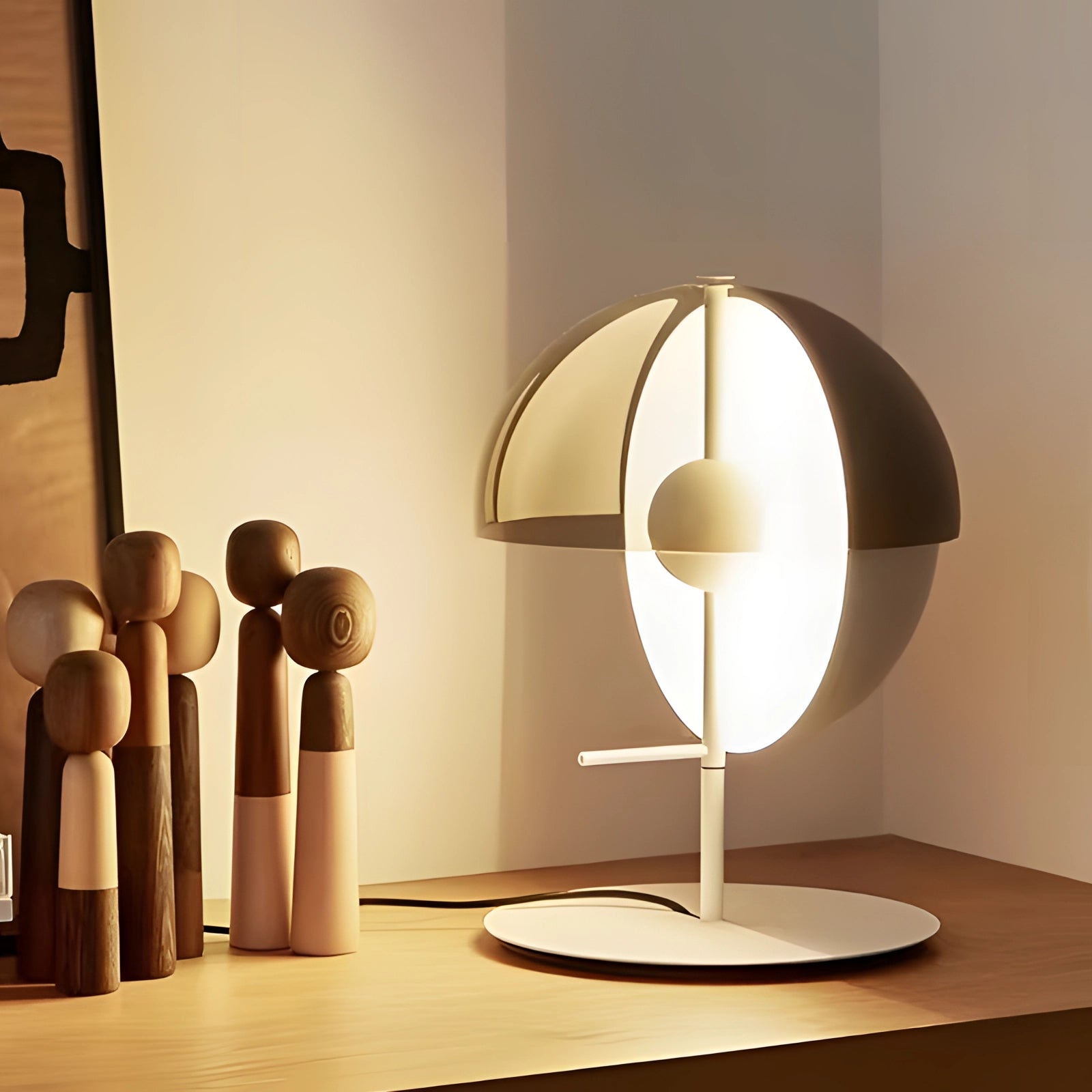 Modern black and gold half-sphere globe desk lamp with adjustable light, featuring a white variant, displayed on a wooden surface, showcasing its sleek design and artistic appeal suitable for interior spaces.