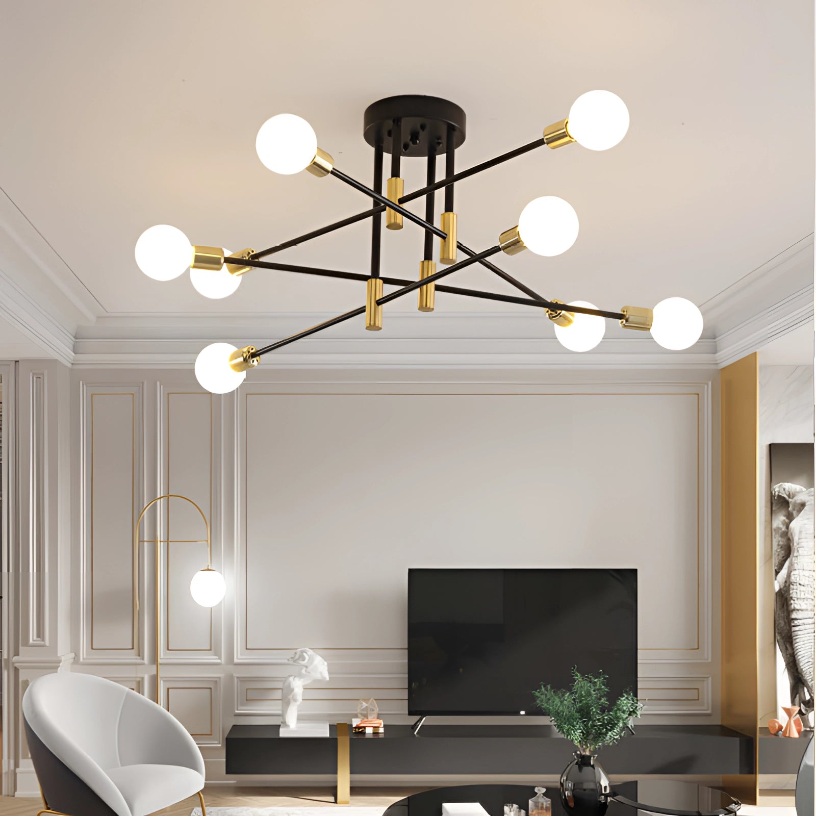 Modern black and gold mid-century adjustable glass chandelier hanging in a stylishly decorated living room with wooden furniture, houseplants, and contemporary interior design elements.