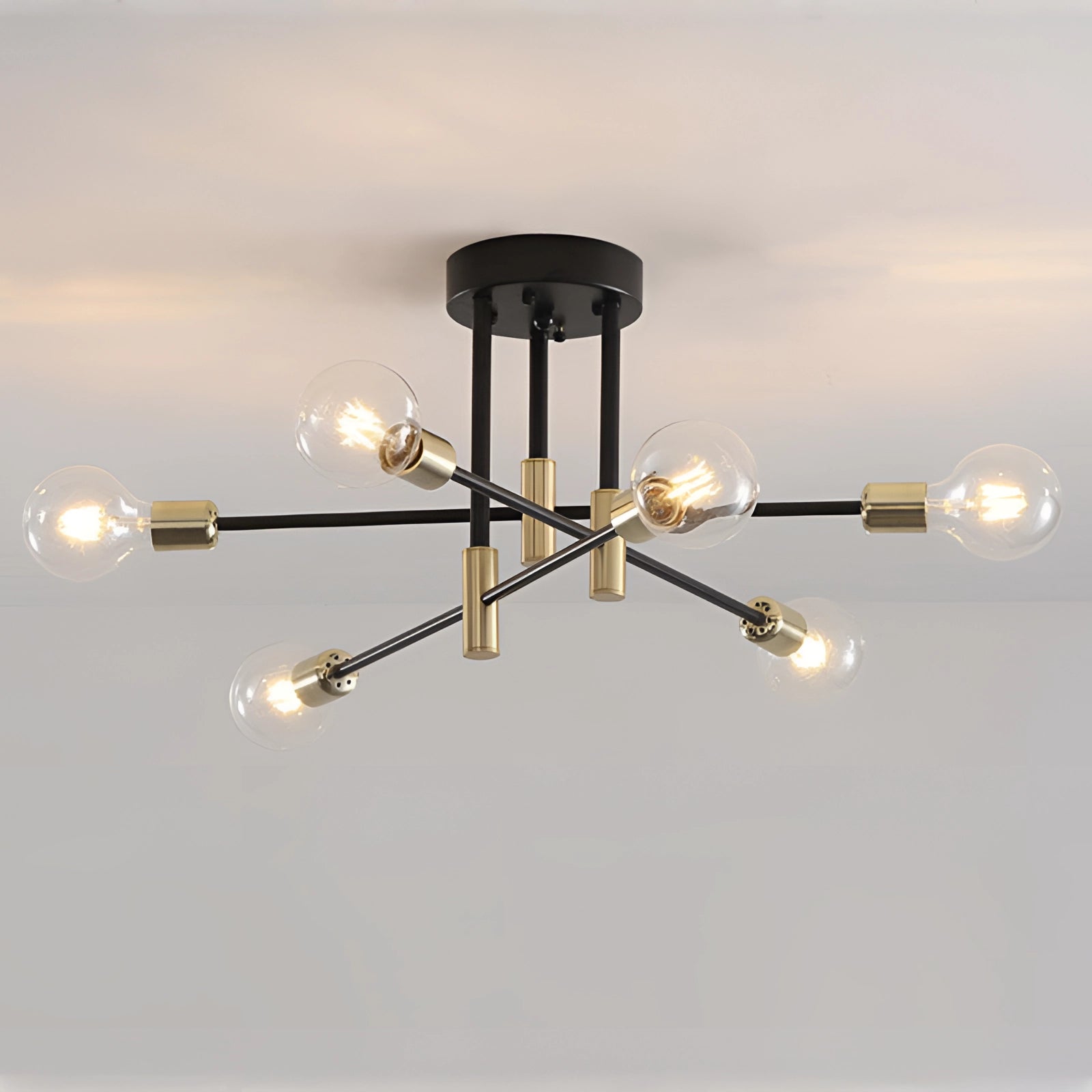 Modern black and gold mid-century adjustable glass chandelier hanging from the ceiling, featuring metal and circular design elements.