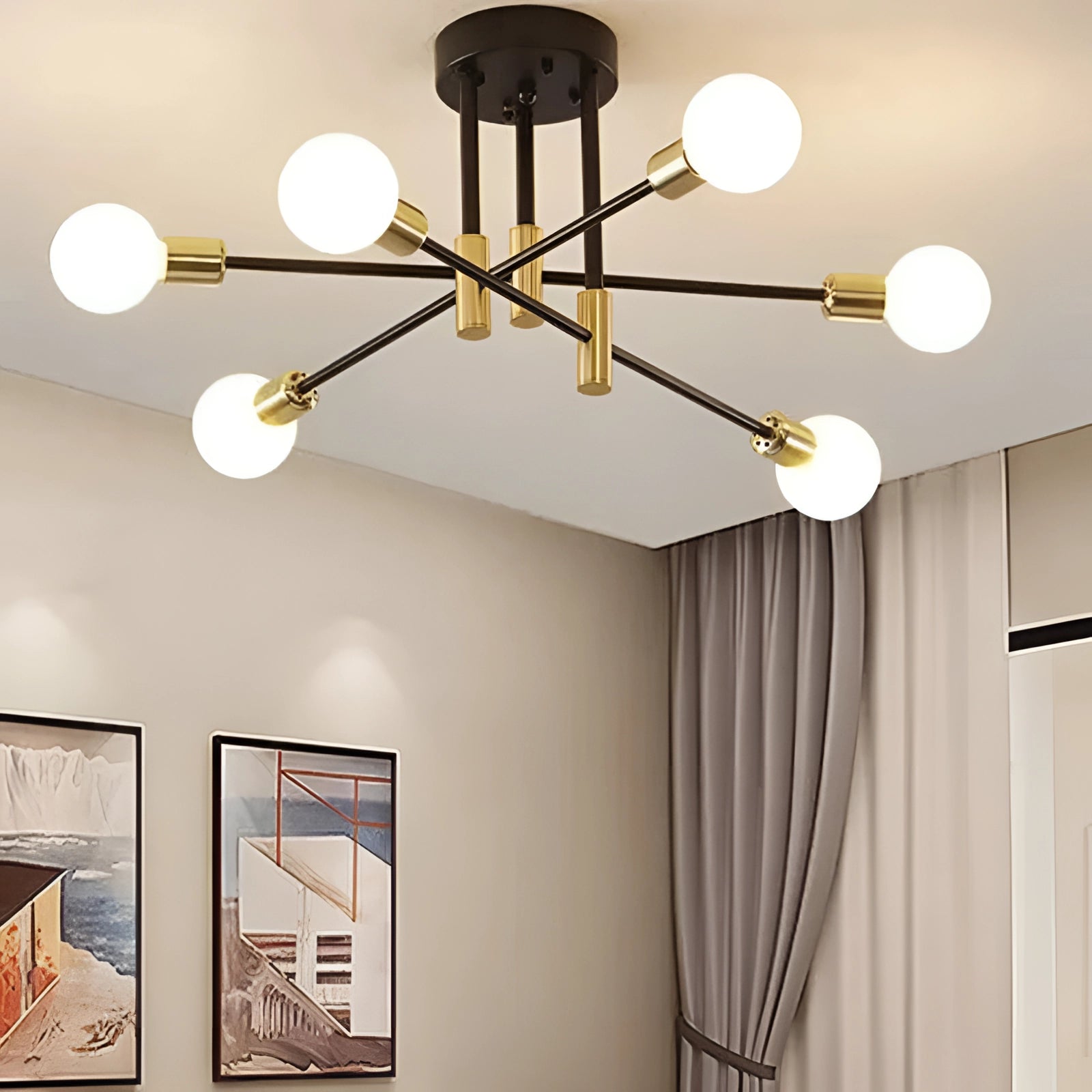 Modern black and gold mid-century adjustable glass chandelier hanging in a stylish, well-lit room with white curtains and framed pictures on the wall.