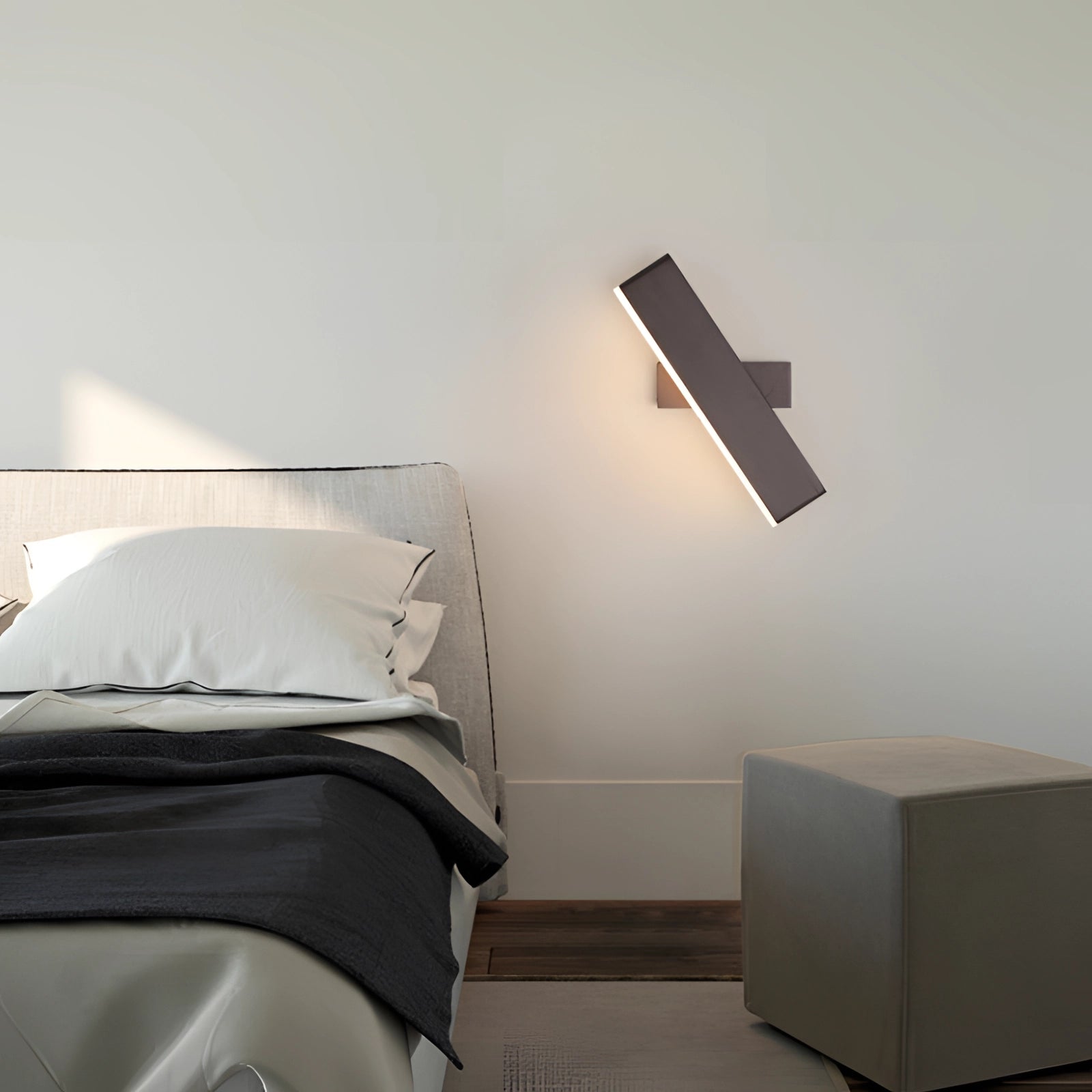 Modern black LED wall sconce with a minimalist geometric design mounted on a grey wall.