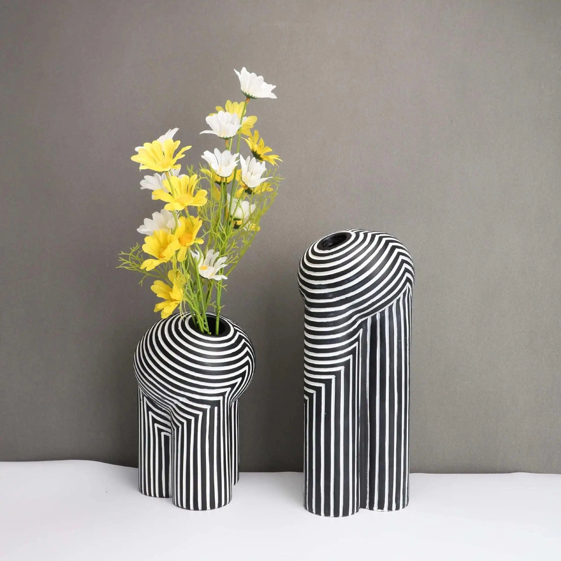 Modern black and white striped ceramic vase with an optical illusion pattern, 25cm in height, designed to hold flowers and houseplants.