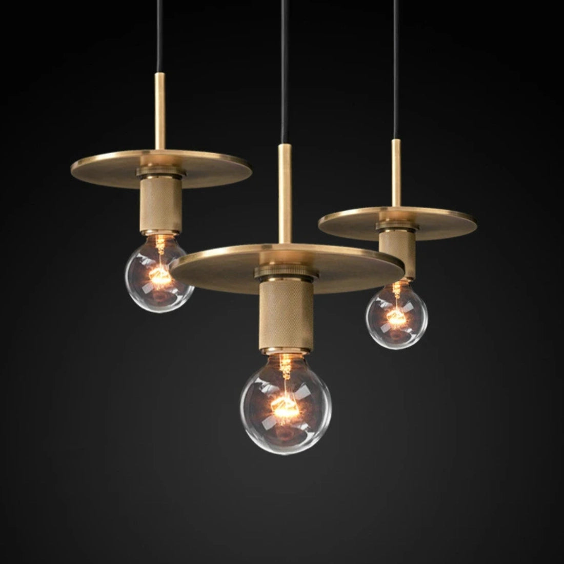 Modern brass finish pendant light with adjustable industrial design, featuring a circular metal ceiling fixture and visible light bulb.