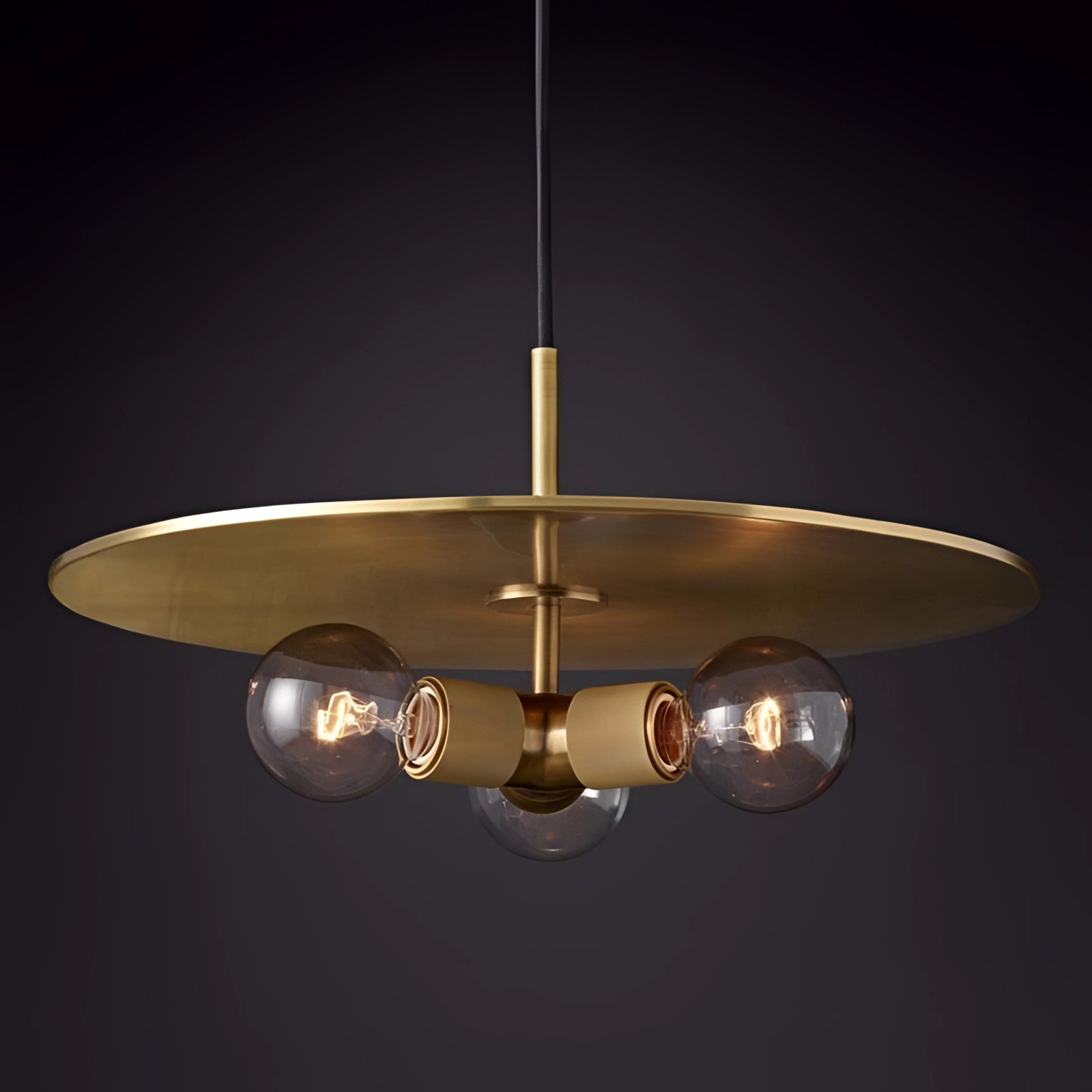 Modern Brass Finish Disc Pendant Light - Adjustable Industrial Lamp hanging above a table, showcasing its sleek design and warm glow.