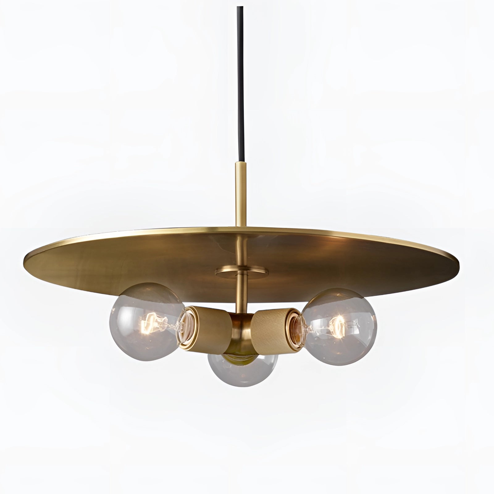 Modern brass finish pendant light with an adjustable industrial design, featuring a sleek lampshade hanging above a wooden table.