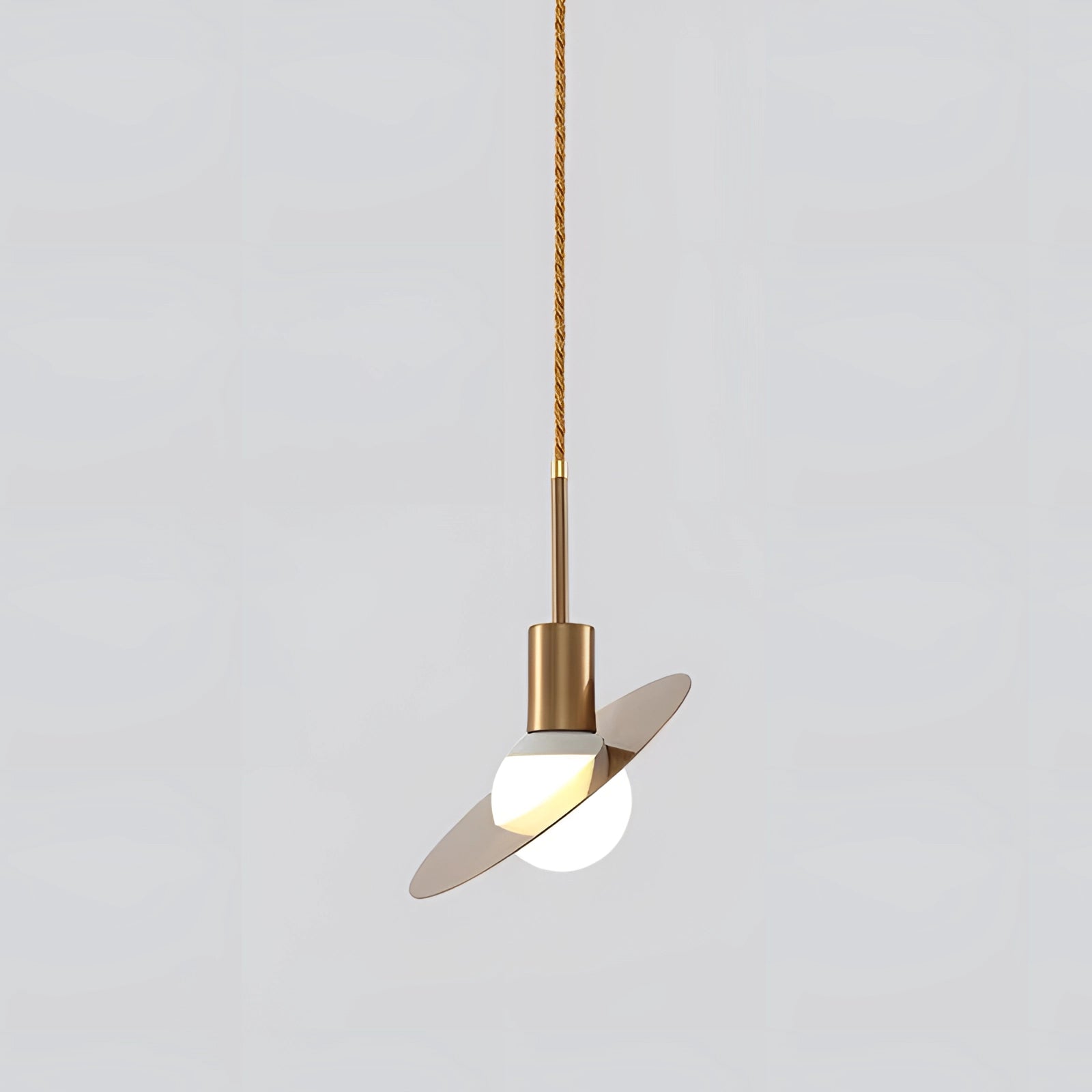 Modern brass geometric pendant light fixture hanging from the ceiling, featuring a luxurious designer style with a small, artistically crafted shape.