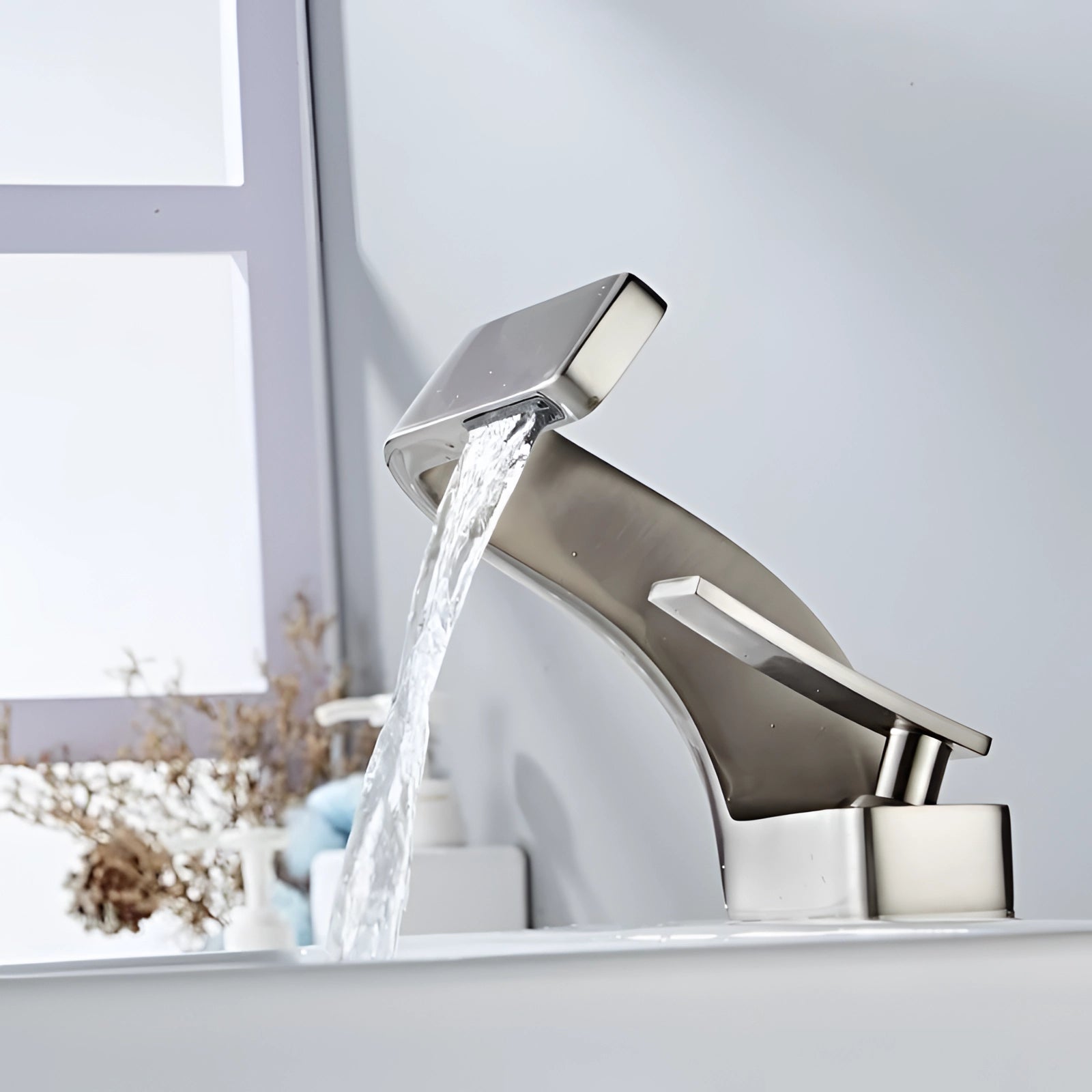 Sleek modern chrome waterfall bathroom faucet with a single-handle design, featuring an elegant and contemporary style perfect for a designer bathroom setting.