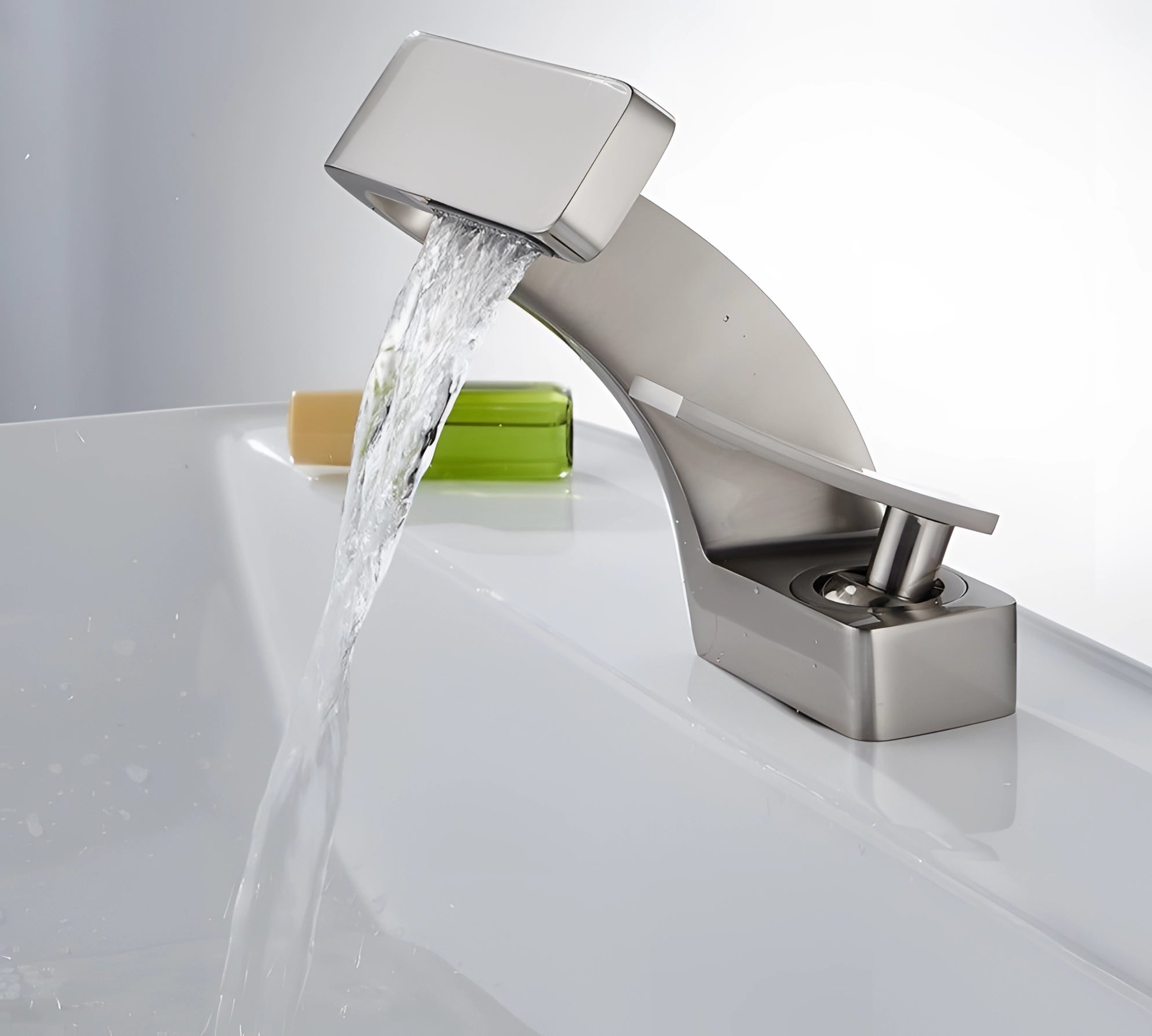 Modern chrome waterfall faucet with a luxury square spout, designed for a basin mixer, shown with water elegantly flowing, highlighting its sleek and contemporary design in a bathroom setting.