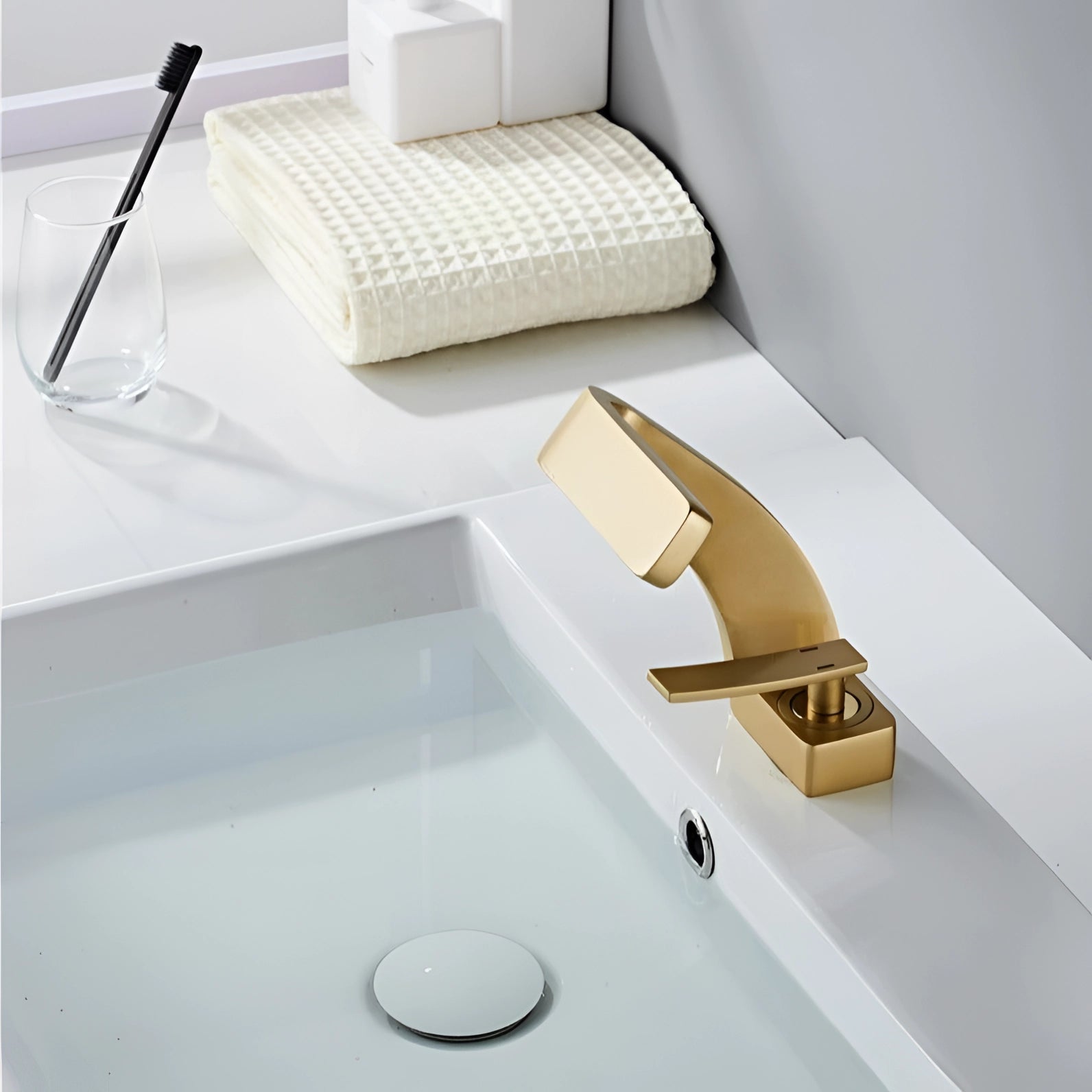 Modern chrome waterfall faucet with a luxury square spout design, mounted on a sleek white rectangular basin, showcasing a contemporary style with emphasis on elegance and functionality.