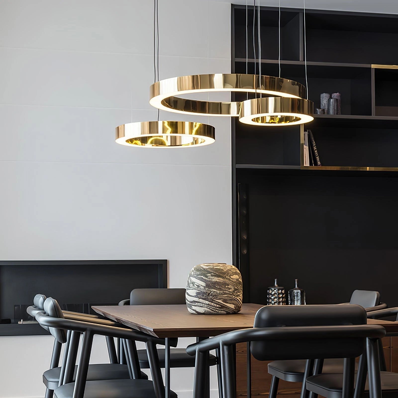 A modern circular LED ring pendant light hanging in a luxurious hotel lobby, illuminating the contemporary interior with its sleek design. The setting includes a well-furnished space with wooden tables and shelving, elegant tableware, and stylish decor elements.