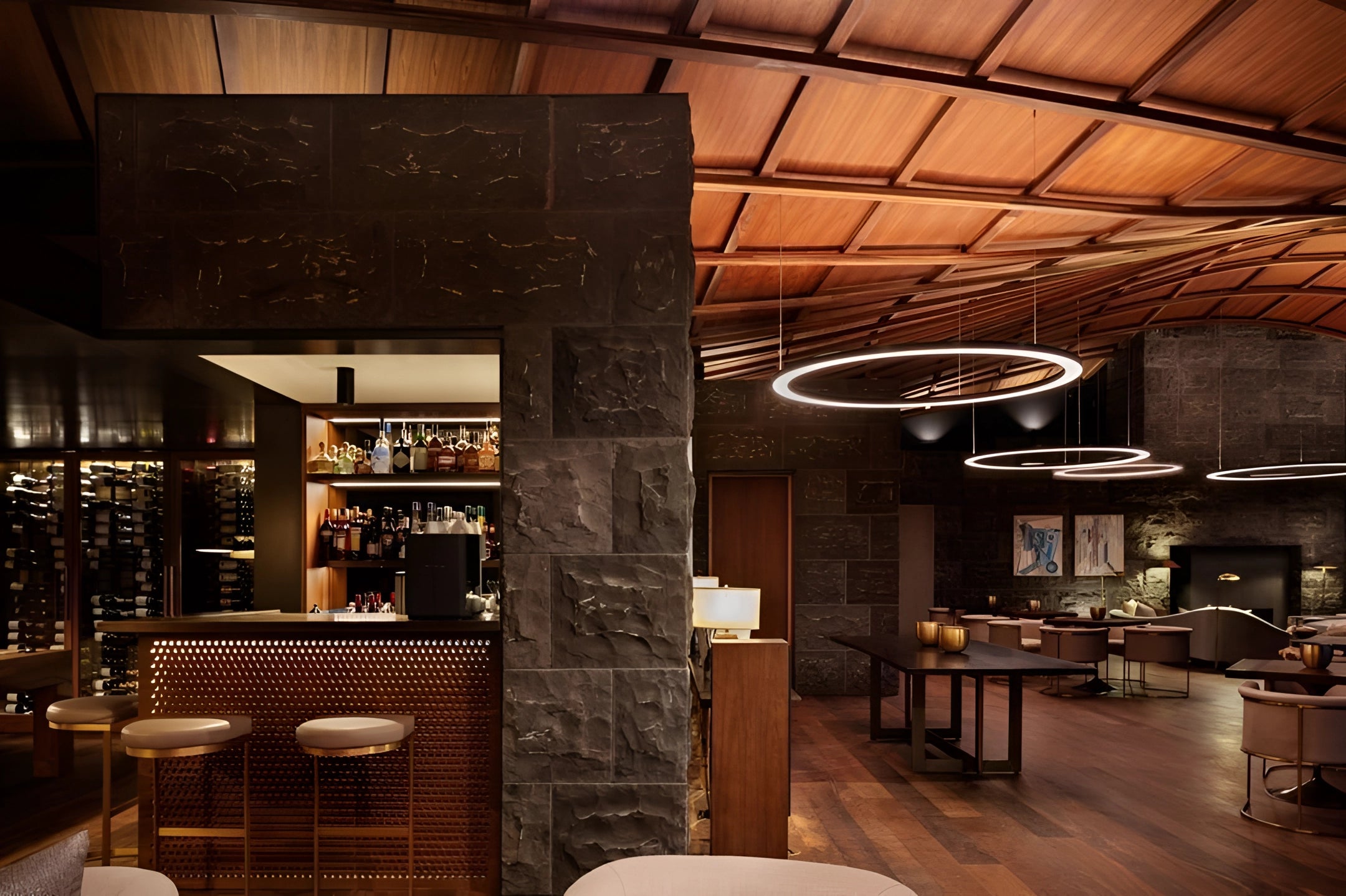 Modern circular LED ring pendant light illuminating a luxury hotel lobby, showcasing sleek interior design with stylish furniture including chairs and tables on a polished wooden floor.