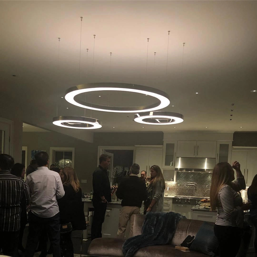 Modern Circular LED Ring Pendant Light hanging from the ceiling in a luxurious hotel lobby setting with stylish interior design elements, including chairs, creating an inviting atmosphere for conversation and events.