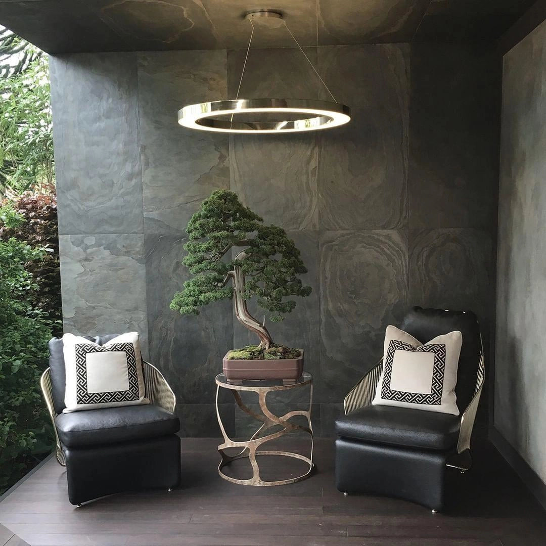 Modern circular LED ring pendant light hanging in a luxurious hotel lobby with contemporary interior design, featuring a blend of comfortable furniture and plants, complementing the building's sophisticated decor.