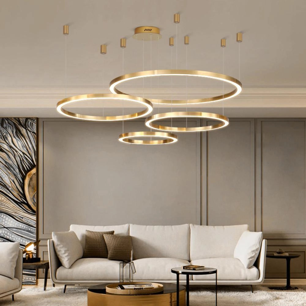 Modern circular LED ring pendant light illuminating a luxury hotel lobby with contemporary interior design, featuring a white couch, wood flooring, and stylish furnishings.