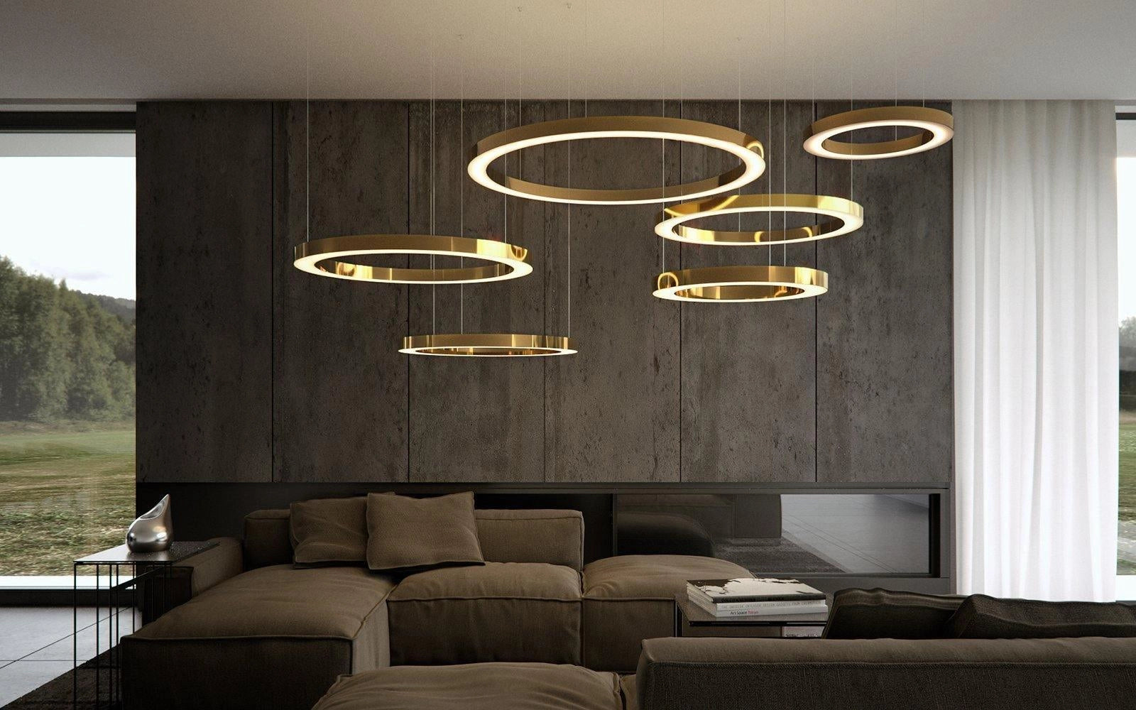 Modern circular LED ring pendant light suspended in a luxury hotel lobby with contemporary interior design elements, featuring wooden accents, a couch, and decorative plants.