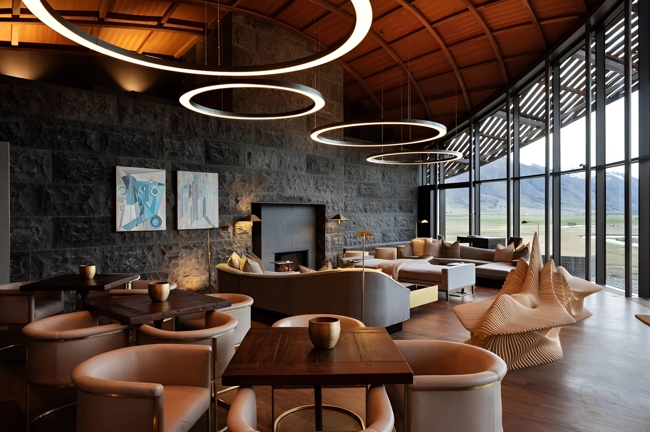 Modern circular LED ring pendant light hanging from the ceiling in a luxury hotel lobby, featuring a stylish and elegant design that complements the contemporary interior setting with wooden floors and upscale furniture, including tables and chairs.