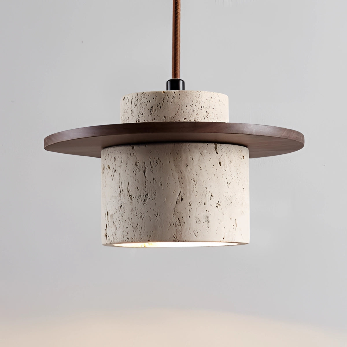 A modern pendant light featuring a concrete shade with an oak wood accent, designed for Scandinavian decor, suspended from the ceiling.