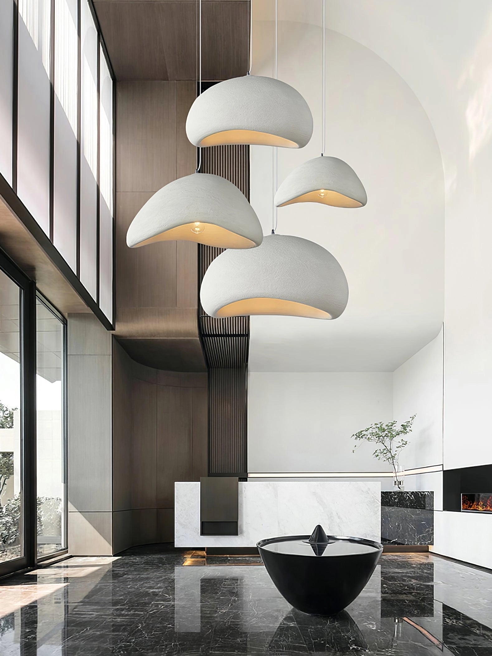 Modern curved pendant light fixture with a minimalist sculptural design, hanging elegantly in a contemporary interior setting, surrounded by neutral-toned walls and flooring, creating a sophisticated and stylish ambiance.