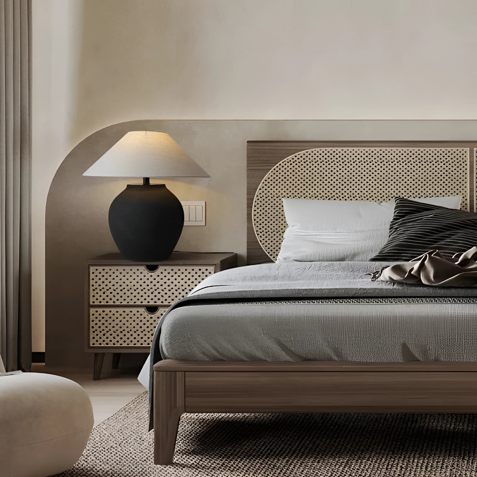 Modern dark wood bedside table with a minimalist design, featuring a shelf underneath. The table is placed beside a bed with a grey pillow and a lamp on top, set on a wood floor and complemented by a neutral-colored shade.