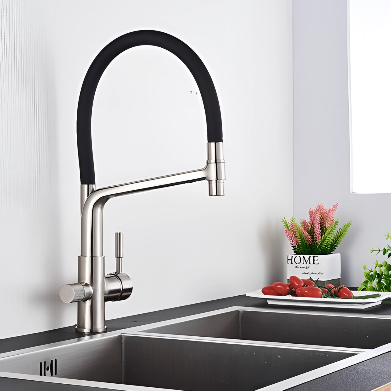 Sleek black and chrome pull-down kitchen faucet with a nickel finish, elegantly designed for dual-functionality, installed over a modern rectangular sink in a contemporary kitchen setting with subtle plant accents.