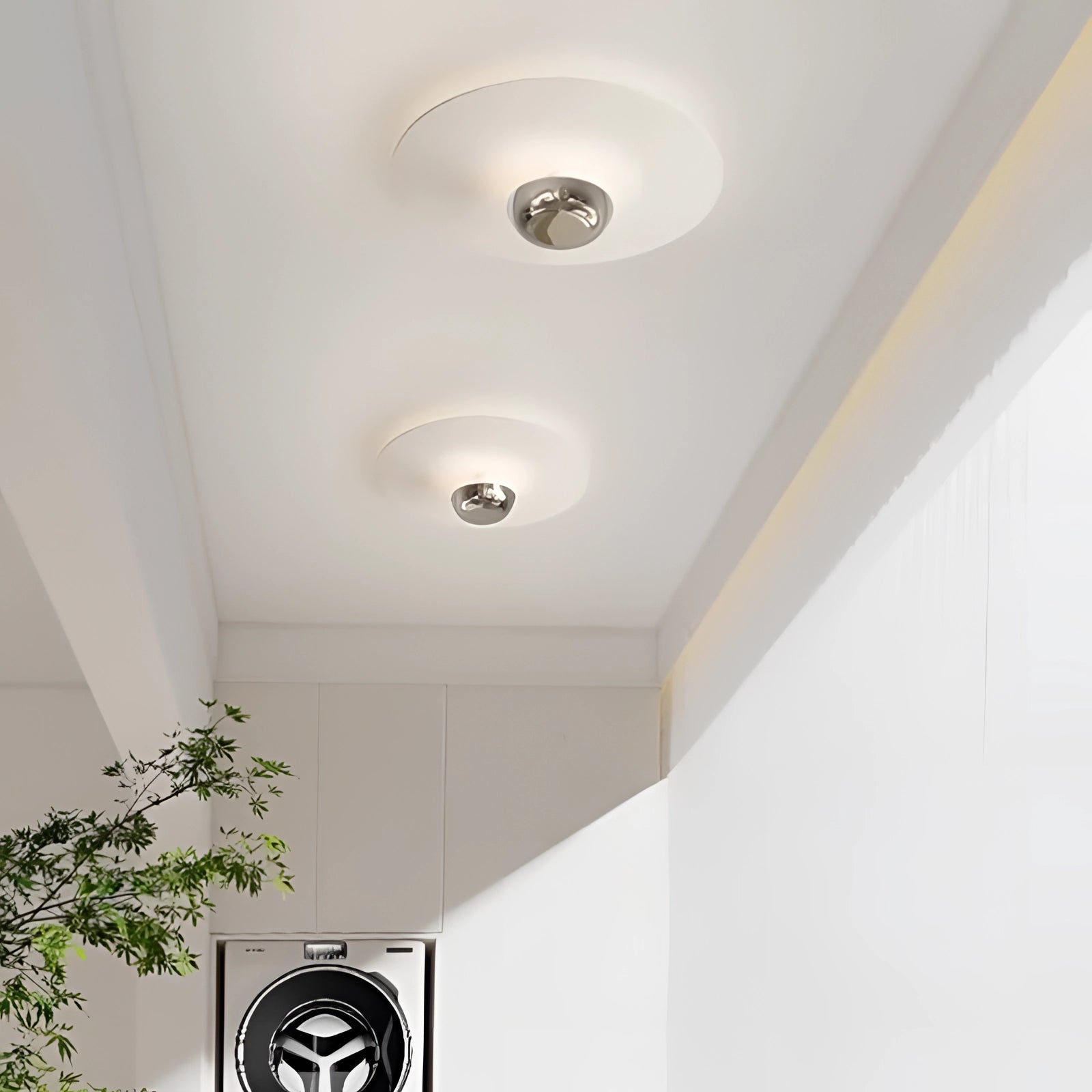 Modern flush mount ceiling light with a sleek minimalist design, featuring a round fixture in white and milk coffee color, installed on a plaster ceiling with wooden flooring and a houseplant nearby.