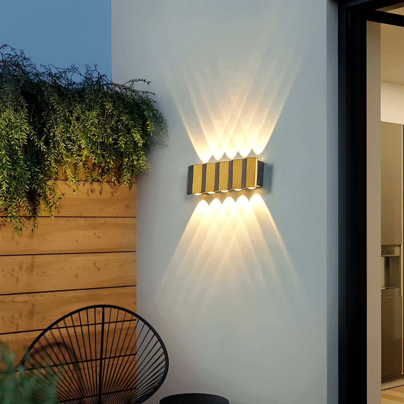 Modern geometric LED wall lamp mounted on an exterior wall of a building, emitting bright white light (5000K) suitable for outdoor spaces.