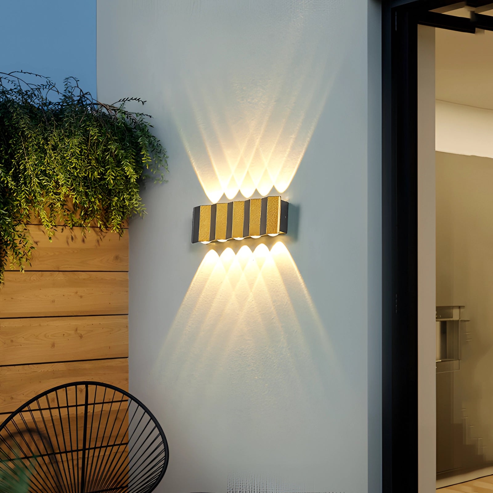 Modern geometric LED wall lamp with warm light (3000K) mounted outdoors on a wooden structure, highlighting its architectural design and providing illumination suitable for Great Britain/Australia.