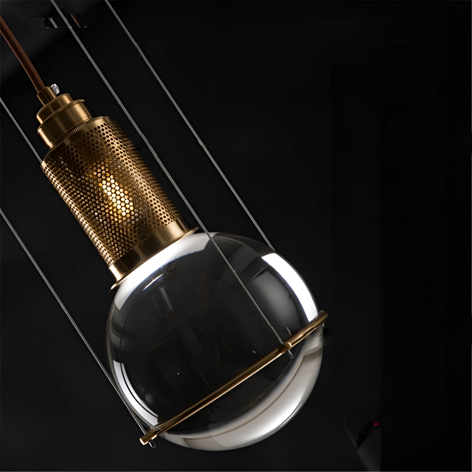 Modern gold glass globe pendant light with a minimalist and designer style, featuring a spherical glass shade suspended from a sleek metallic fixture.