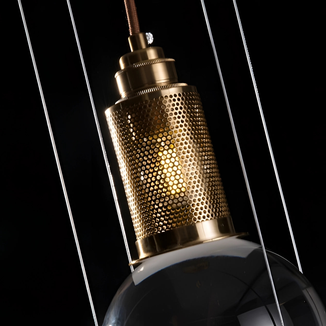 Modern glass globe pendant light with a gold finish, featuring a minimalist and designer style, showcasing a sleek glass and metal construction as part of a contemporary light fixture.