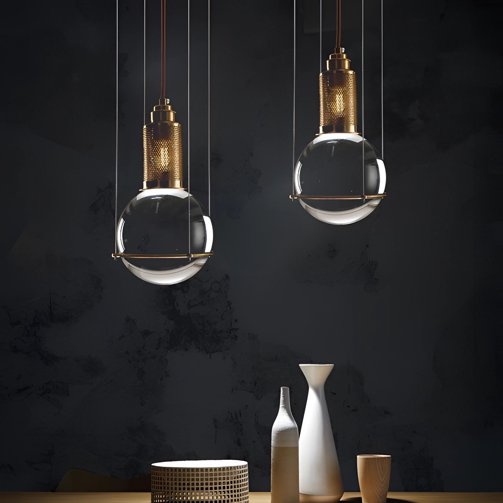 Modern glass globe pendant light with a gold finish, hanging from the ceiling. The minimalist design features a spherical glass shade that diffuses light evenly, enhancing any interior space with a touch of elegance and contemporary style.