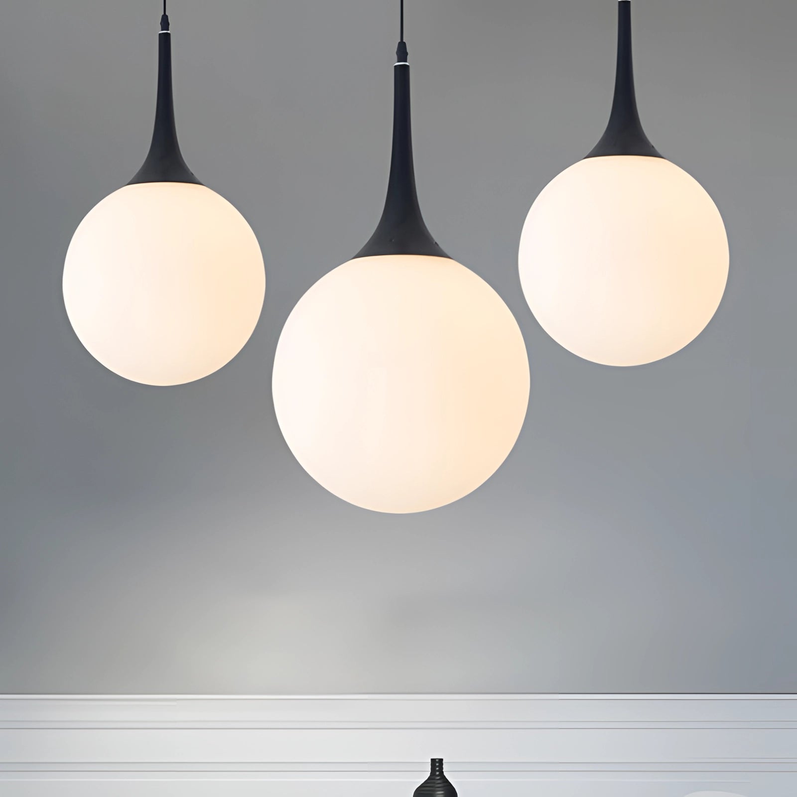 Modern Globe Pendant Light in black and white glass hanging from the ceiling, featuring sleek, symmetrical design with circular elements.