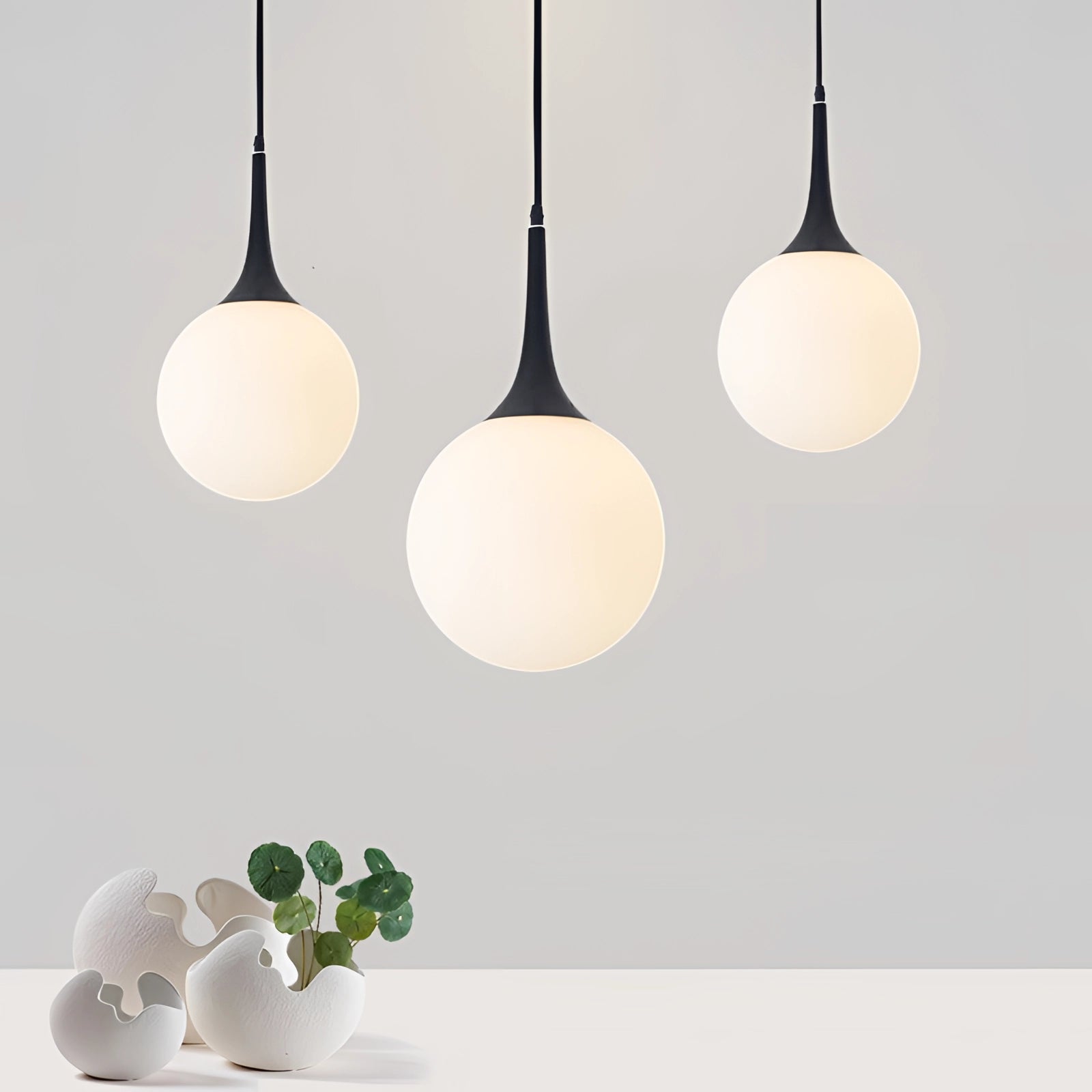 Modern Globe Pendant Light in Black & White Glass, 8-inch Designer Ceiling Lamp, emitting soft white light, hanging from the ceiling.