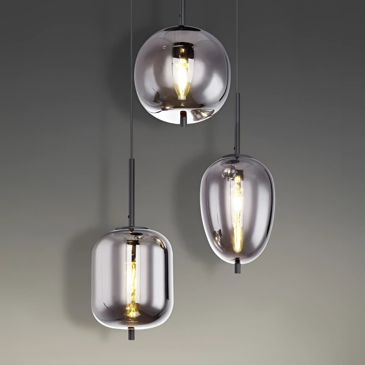 Modern industrial glass pendant lights with bronze finish hanging from the ceiling in a dining room.